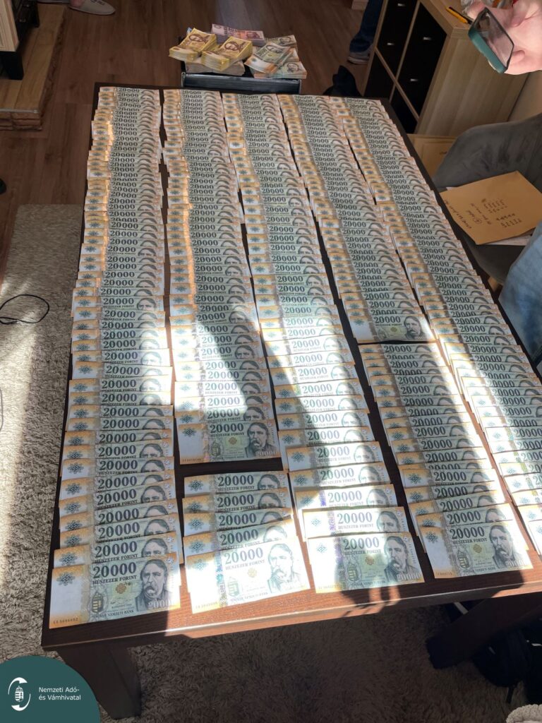 Lefoglalt készpénz kötegek és édességdoboz az asztalon, NAV-felvétel