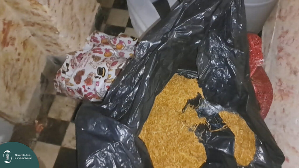 Vágott dohánnyal teli fekete zsák és egyéb csomagok egy átvizsgált helyiségben, a NAV ellenőrzésekor