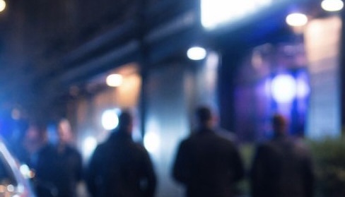 Éjszakai jelenet egy budapesti szórakozóhely előtt, elmosódott alakokkal és kékes fényekkel