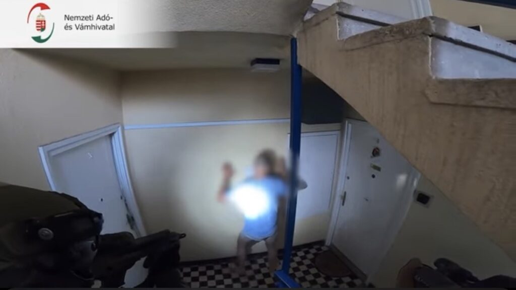 Fegyveres NAV pénzügyőrök intézkednek egy lépcsőházban egy gyanúsított elfogásakor