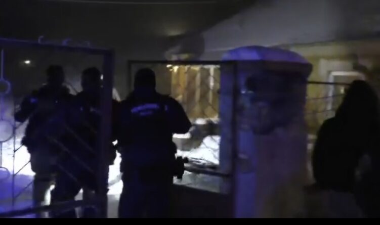 Rendőrök éjszakai akció során egy tapolca környéki ingatlan kapujánál, ahol emberkereskedelem gyanúja miatt intézkedtek