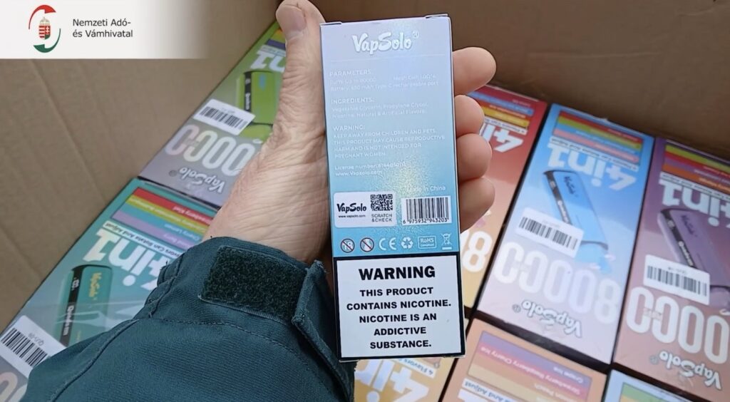 VapSolo elektromos cigaretta doboza nikotin figyelmeztetéssel kézben tartva