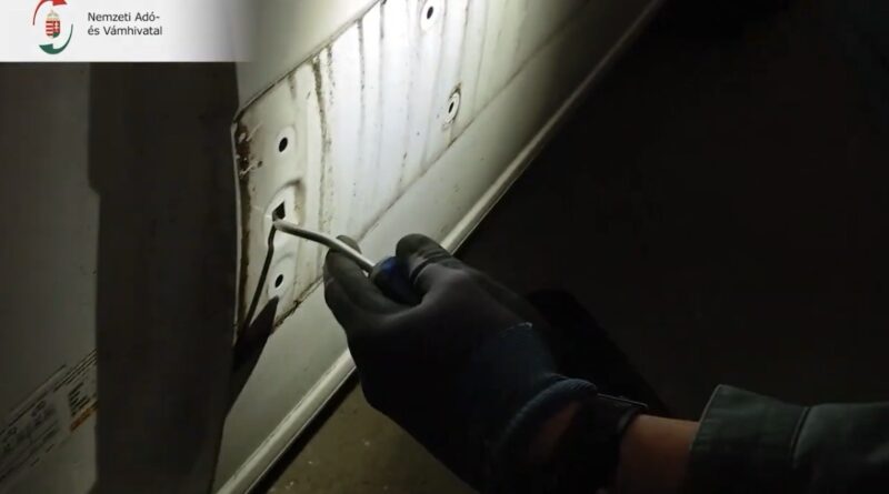 NAV pénzügyőr csavarhúzóval bontja meg a kisteherautó oldalfalát ellenőrzés közben