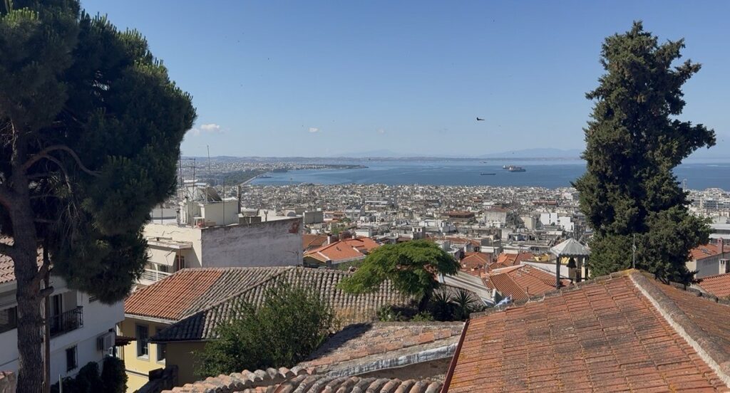 Panorámás kilátás Thesszaloniki vörös tetőire és a tengeröbölre egy magasabb pontról.