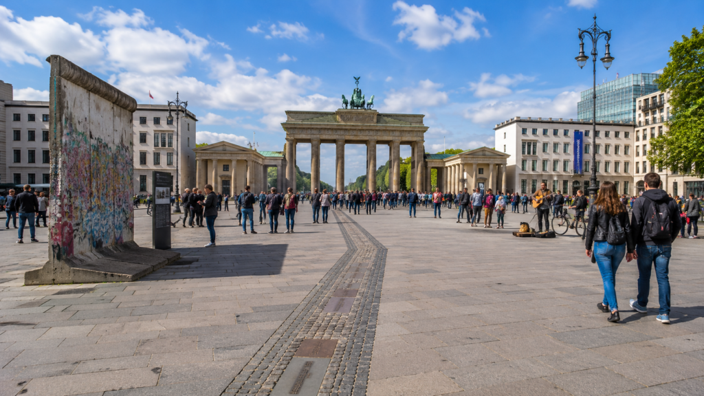 Turisták és helyiek a Brandenburgi kapu előtt, az egykori berlini fal nyomvonalán.