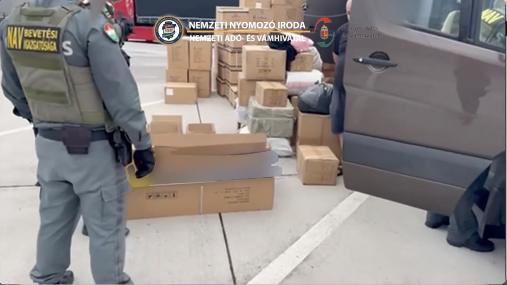 NAV és KR NNI akció a magyar–szlovák határon, ahol a rendőrök fegyverszállítmányt ellenőriznek a lefoglalt dobozok mellett.