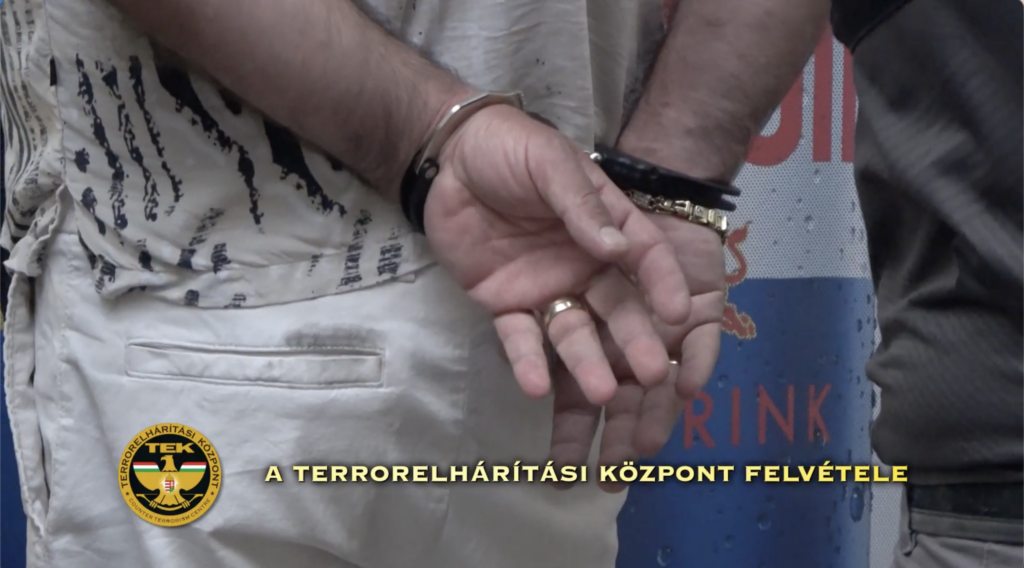 Megbilincselt gyanúsított kezei az illegális fegyverkereskedelem miatt végrehajtott rendőrségi akció során.
