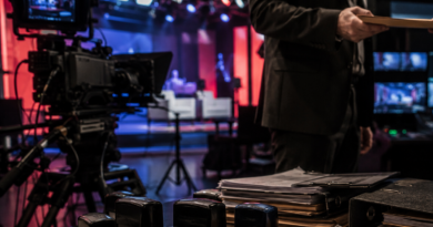 Televíziós stúdió kulisszái dokumentumokkal, bélyegzőkkel és filmes felszereléssel.