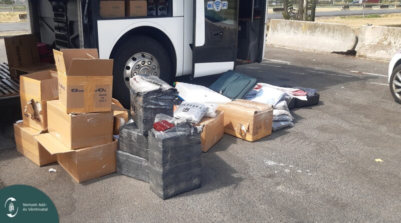 elöletlen kartondobozok és bőröndök egy autóbusz mellett az M1-es autópályán, amelyekből hamis luxuscikkek kerültek elő a NAV ellenőrzése során.