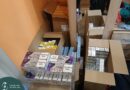 Nyitott kartondobozok és cigarettakartonok a családi ház tükrös szekrénye mellett